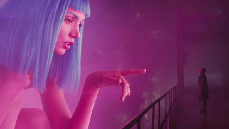 Woman in purple wig pointing out of screen at man in the shadows